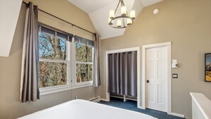 A bedroom with a bed, a window with curtains, a door, and a chandelier. - Snowy Peak Views From Living Room, 2 Parking Spaces, Walk To Ski 1 Bedroom Condo by RedAwning (Telluride)