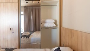 A hotel room with a bed, a wardrobe, and a mirror reflecting the room. - Huma Klabin (São Paulo)