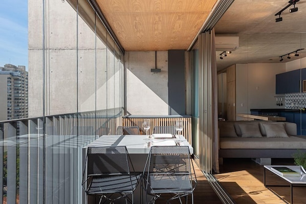 Un apartamento moderno con balcón, comedor y sala de estar.