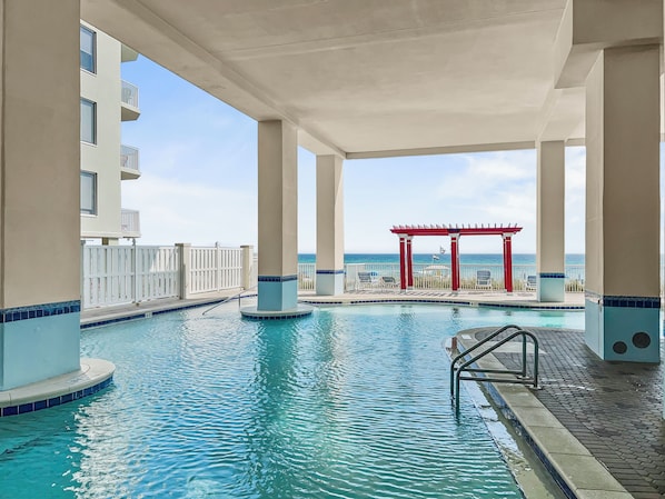 Una piscina al aire libre, sombrillas, sillones reclinables de piscina