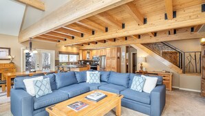 A spacious living room with a large blue sectional sofa, wooden coffee table, and exposed wooden beams. - Giant Riverfront Deck W Grill, Tons Of Space @ Viking Lodge 100ab 4 Bedroom Condo by RedAwning (Telluride)