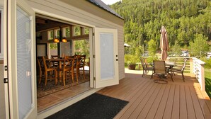 A deck with outdoor furniture and a view of a forested mountain. - Giant Riverfront Deck W Grill, Tons Of Space @ Viking Lodge 100ab 4 Bedroom Condo by RedAwning (Telluride)