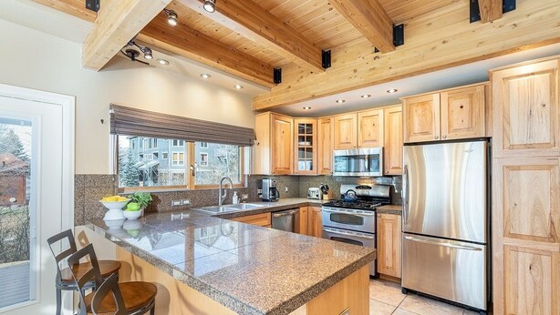 A modern kitchen with wooden cabinets, granite countertops, stainless steel appliances, and a large island with seating. - Giant Riverfront Deck W Grill, Tons Of Space @ Viking Lodge 100ab 4 Bedroom Condo by RedAwning (Telluride)