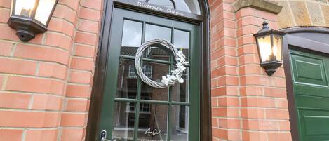 A green door with a glass panel and a wreath, labeled "Riverside Chapel" and "4a High Street."