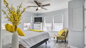 A bedroom with a bed, a chair, a ceiling fan, and a window. - Galveston Retreat w/ Backyard & Patio! (Galveston)