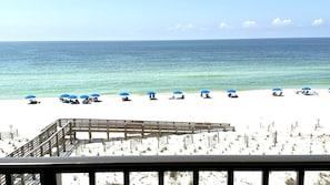 A beach with white sand and a wooden deck in the foreground. - OceanFront, BeachFront, Private Balcony, Pool, Low Density, Boating, Tennis (Orange Beach)