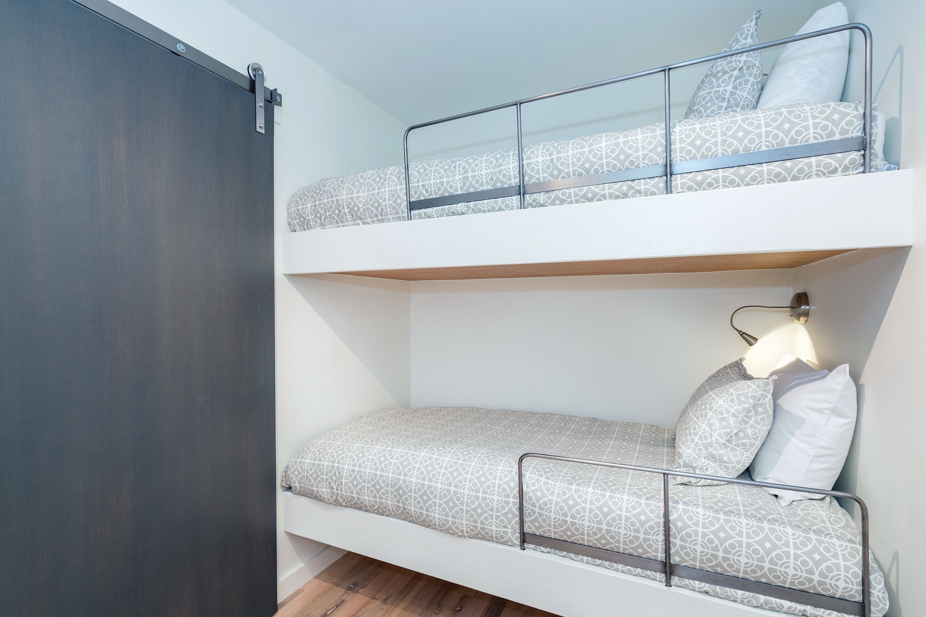 A bunk bed with a metal frame and patterned bedding.