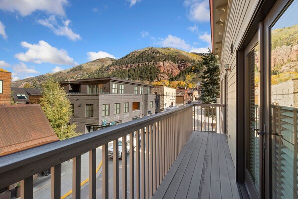 A balcony with a view of a mountain and buildings.