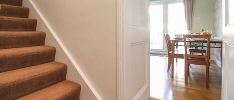 A staircase leading to a dining area with a table and chairs.
