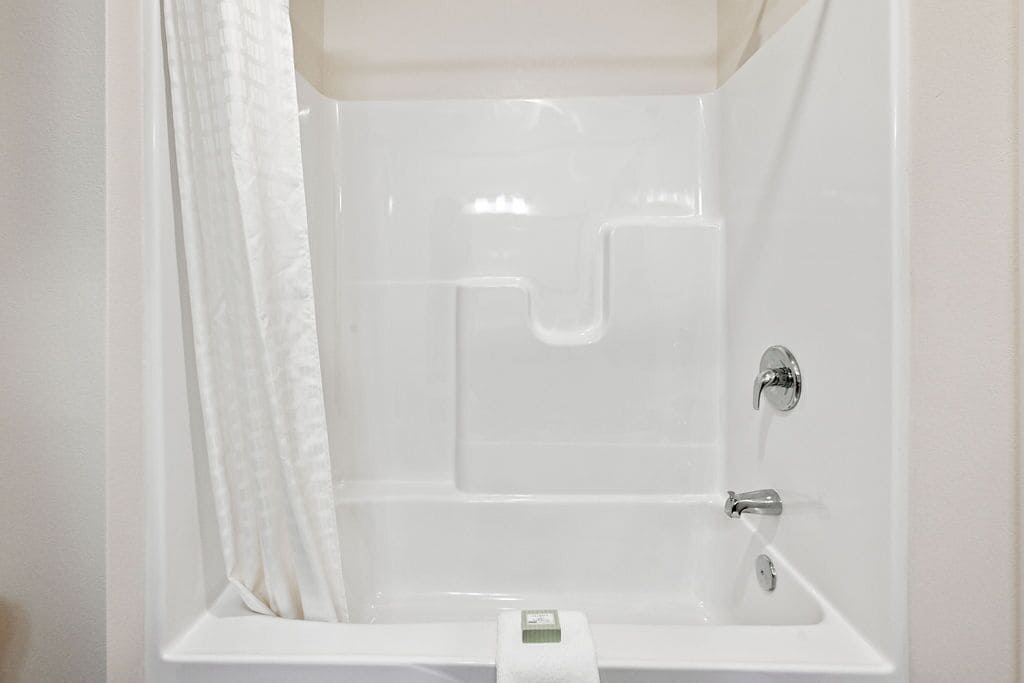 Une salle de bain blanche avec une douche, des toilettes et un lavabo.