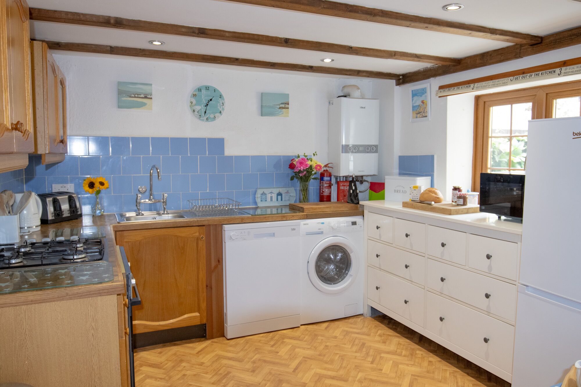 A kitchen with a washing machine, a stove, and a sink.