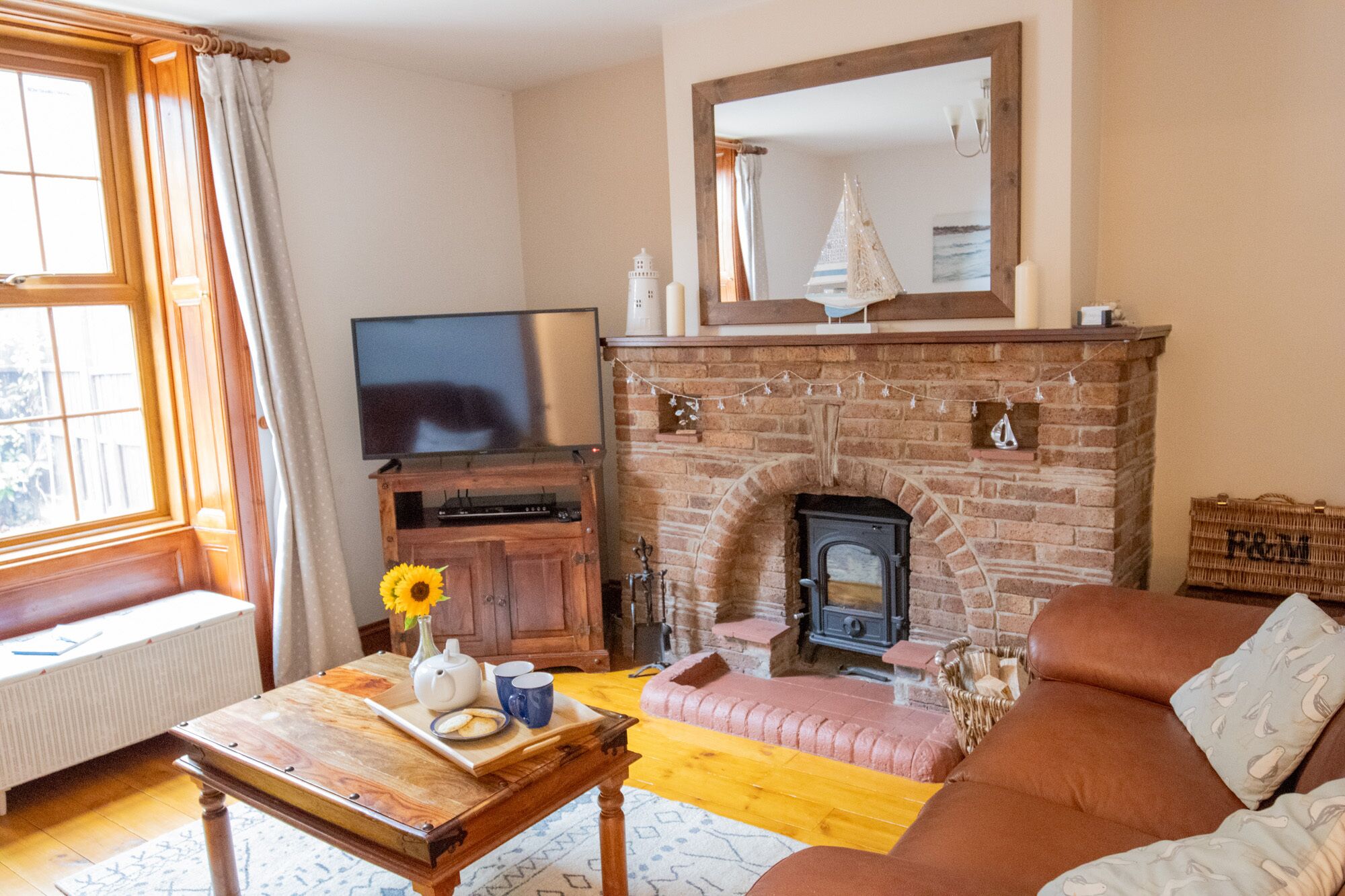 A cozy living room with a fireplace, a television, and a comfortable sofa.