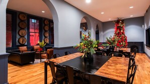 A dining area with a wooden table and chairs, a Christmas tree, and a fireplace.