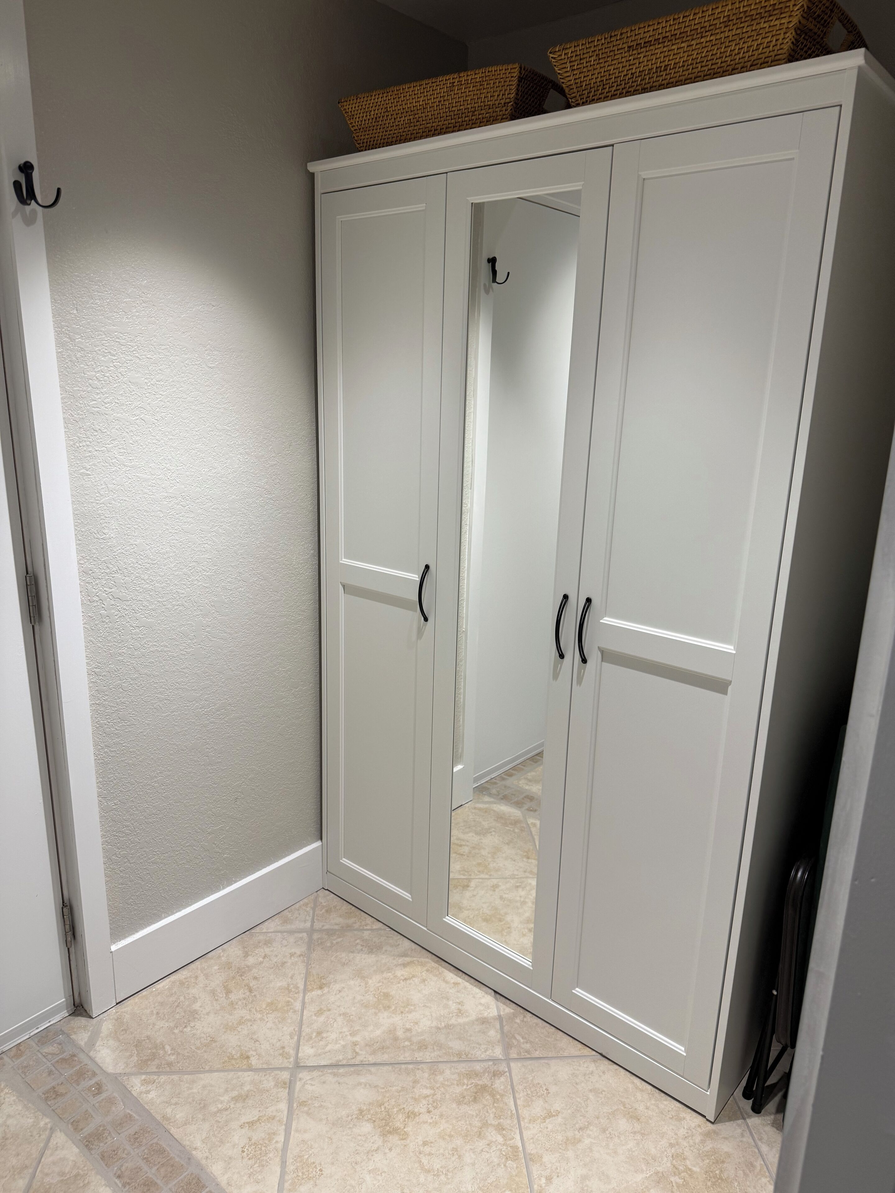 A white wardrobe with two doors and a mirror.