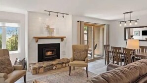 A modern living room with a fireplace, a stone bench, and a leather sofa.