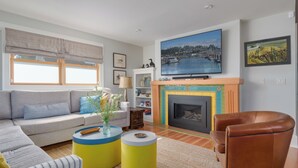 Una sala de estar con sofá, sillones, chimenea y televisión.