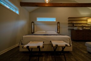 Ein Schlafzimmer mit einem Bett, zwei Nachttischen, einer Kommode und einem Fenster.