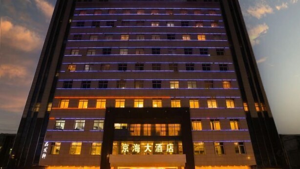 A hotel with multiple floors, illuminated windows, and a prominent entrance with signage. - Pucheng Jinghai Hyatt Hotel (Pucheng)