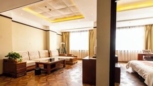 A hotel room with a sofa, a desk, a bed, and a patterned floor. - Pucheng Jinghai Hyatt Hotel (Pucheng)