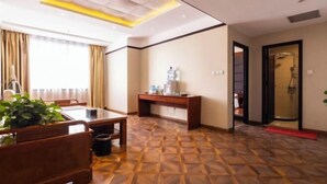 A hotel room with a wooden floor, a dining table, a small desk, a plant, and a shower area. - Pucheng Jinghai Hyatt Hotel (Pucheng)