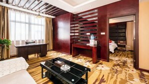 A hotel room with a bed, a desk, a coffee table, and a wardrobe. - Pucheng Jinghai Hyatt Hotel (Pucheng)