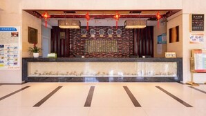 A reception area with a stone wall, a reception desk, and a potted plant. - Pucheng Jinghai Hyatt Hotel (Pucheng)