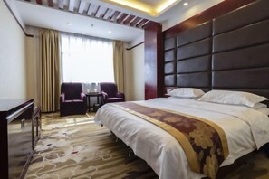 A hotel room with a large bed, a desk, and two chairs. - Pucheng Jinghai Hyatt Hotel (Pucheng)