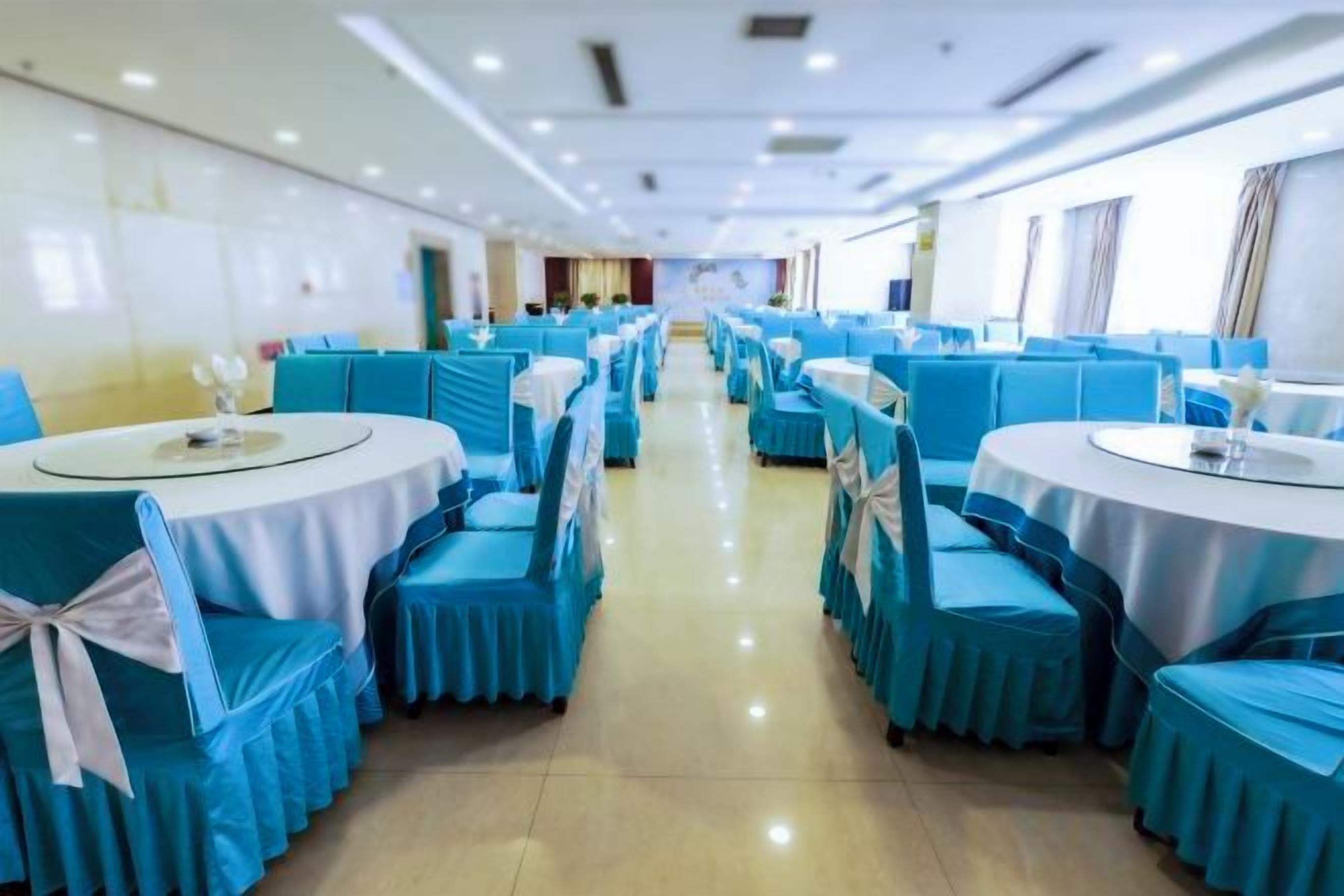 A banquet hall with round tables and chairs, arranged in rows.