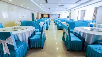 A banquet hall with round tables and chairs, arranged in rows.