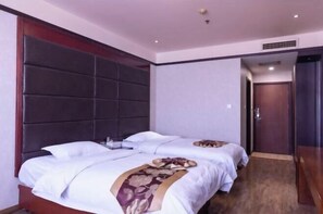 A hotel room with two beds, a dark headboard, a wooden door, and a carpeted floor. - Pucheng Jinghai Hyatt Hotel (Pucheng)