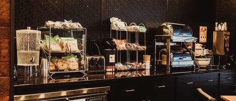 A buffet area with various food items and a coffee machine.