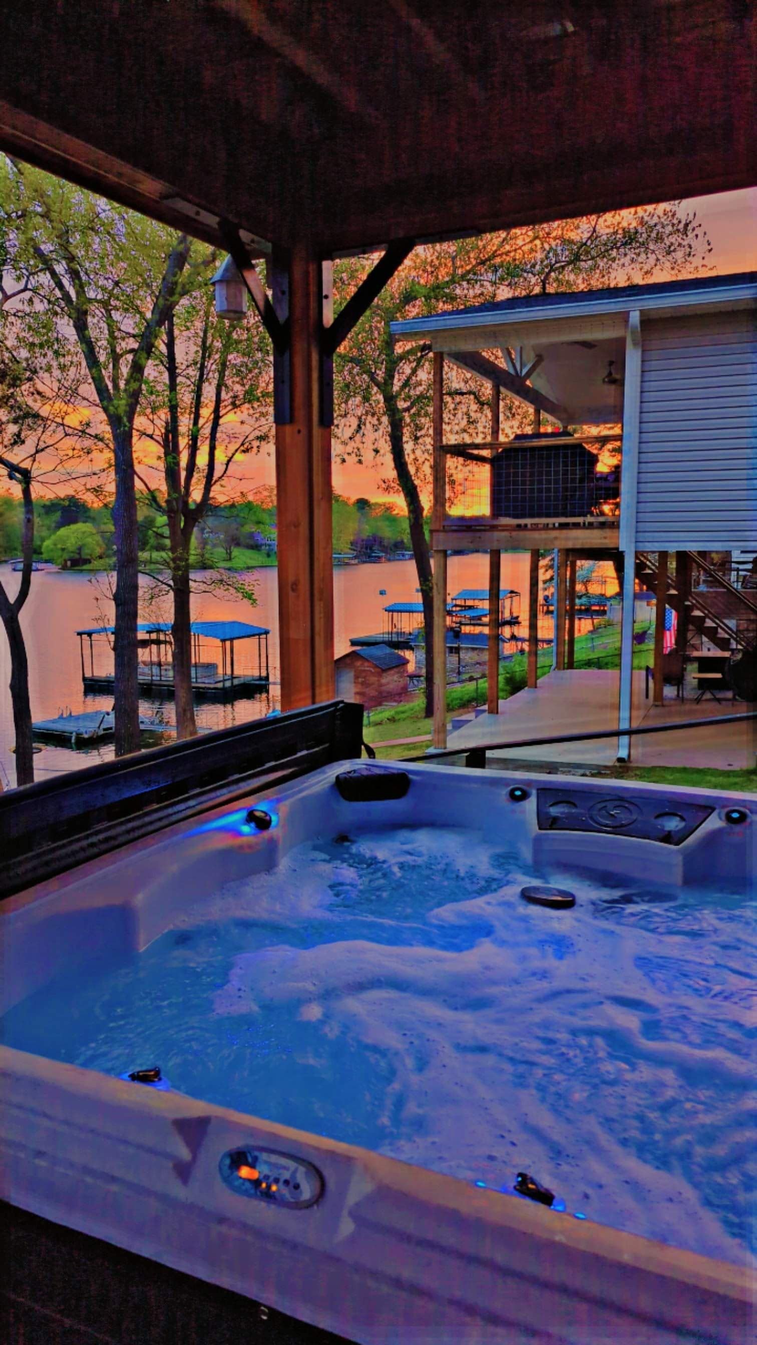 Ein Whirlpool mit Blick auf einen See und ein Haus im Hintergrund.