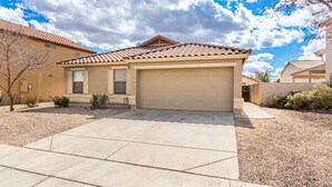 A single-story house with a beige facade, a red-tiled roof, and a garage. - Your Home away from Home (Goodyear)