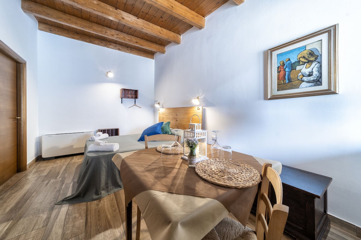 Un comedor con una mesa de madera, sillas y un cuadro en la pared.