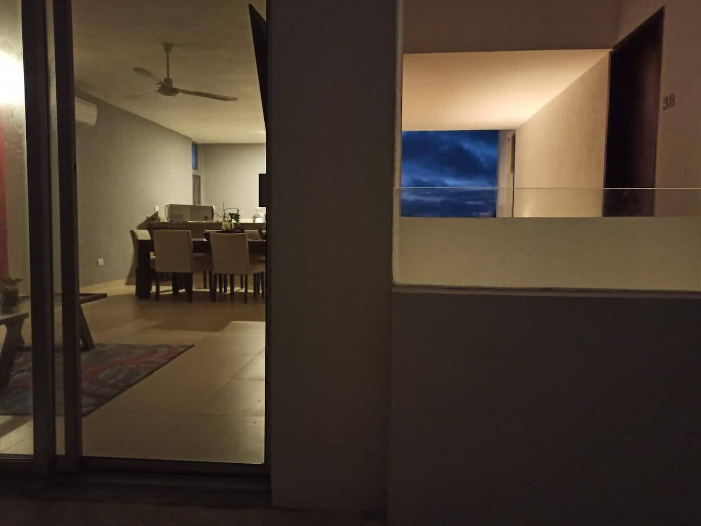 Ein modernes Interieur mit Essbereich, Deckenventilator und Blick zum Himmel durch ein Fenster.