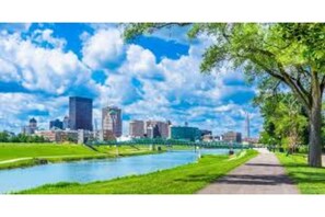 Stroll through the serene urban oasis, surrounded by lush greenery and a tranquil body of water.