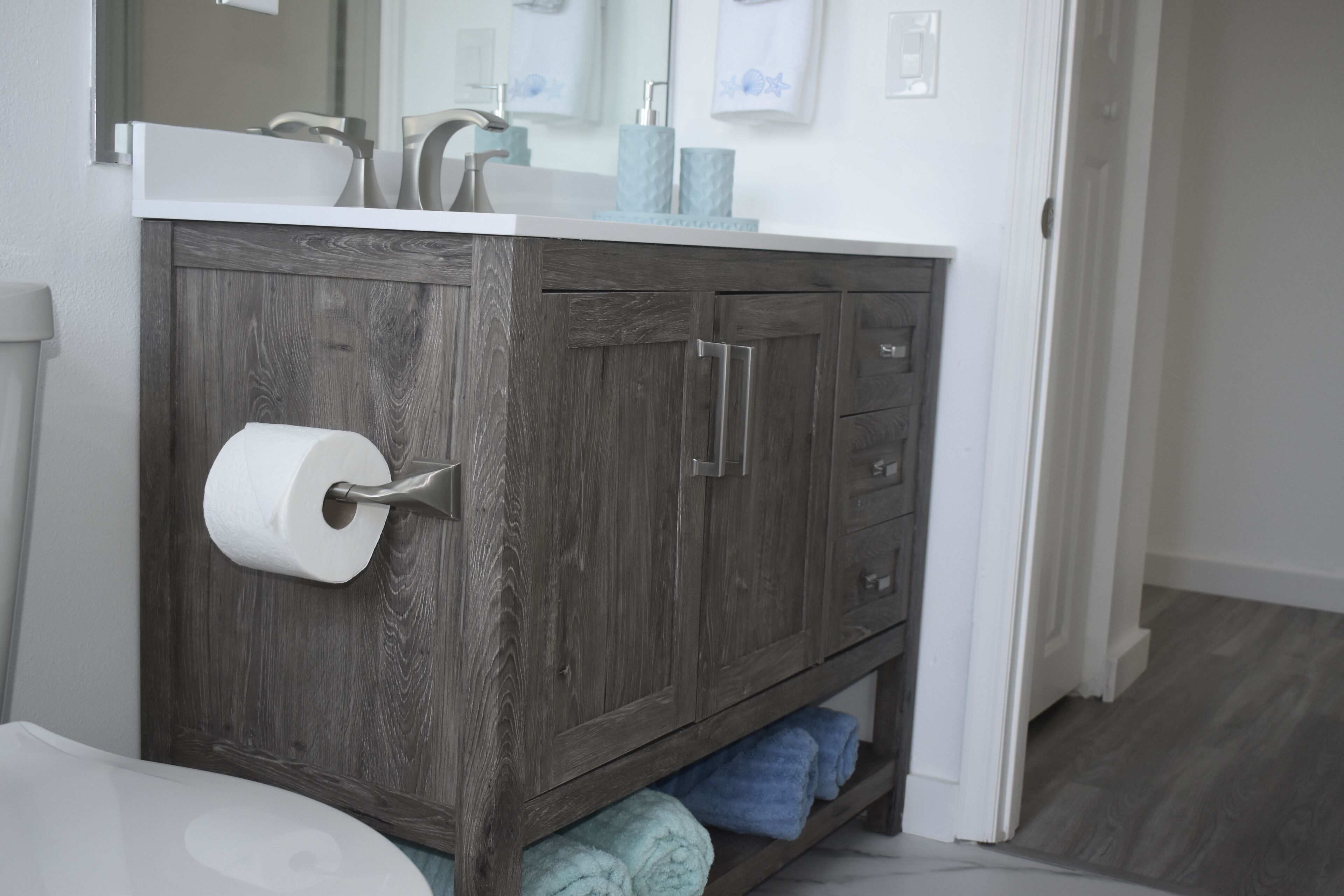Une salle de bain avec un meuble-lavabo en bois, des toilettes et un lavabo.