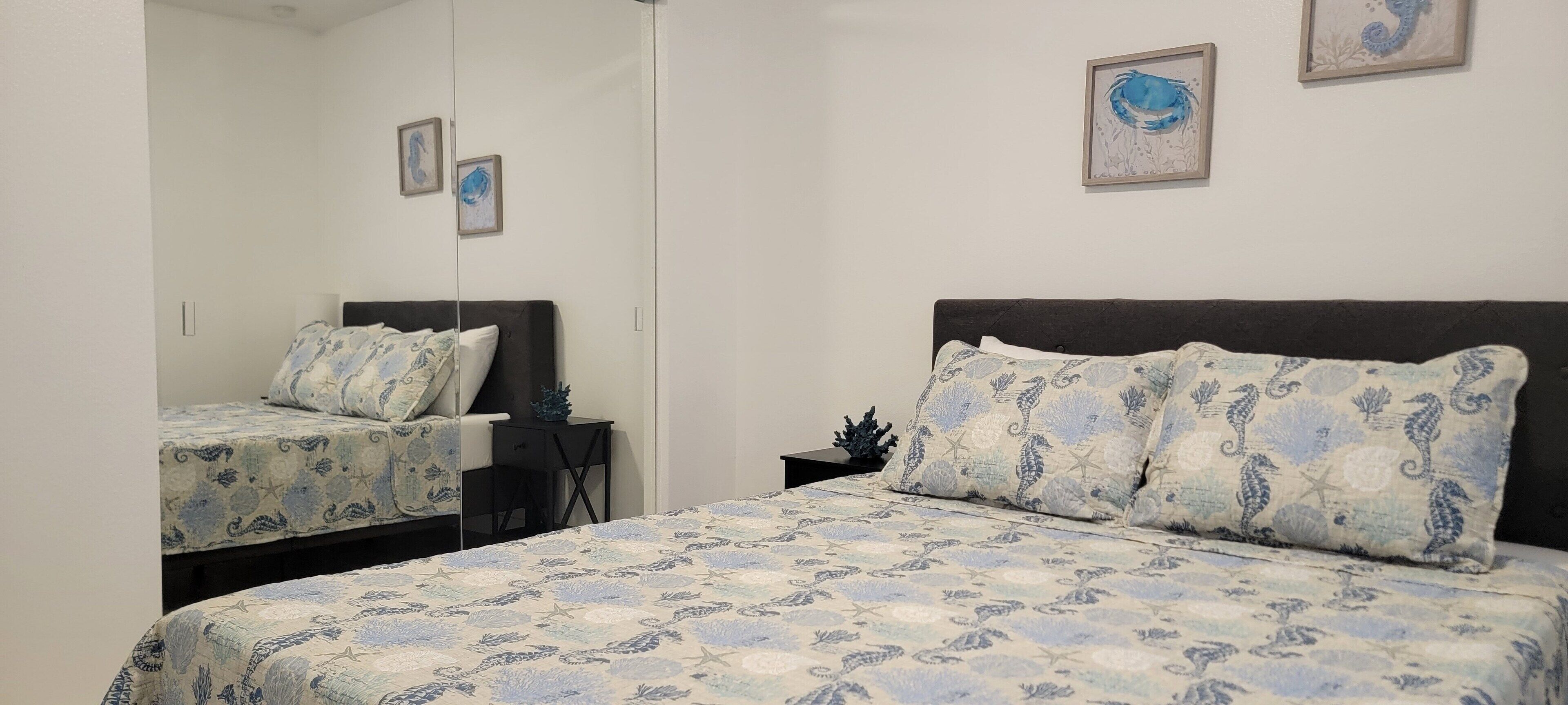 Un dormitorio con dos camas, una mesita de noche y un espejo.