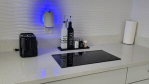 En køkkenbordplade med en brødrister, en flaske eddike, en flaske salt og en papirhåndklædeholder.