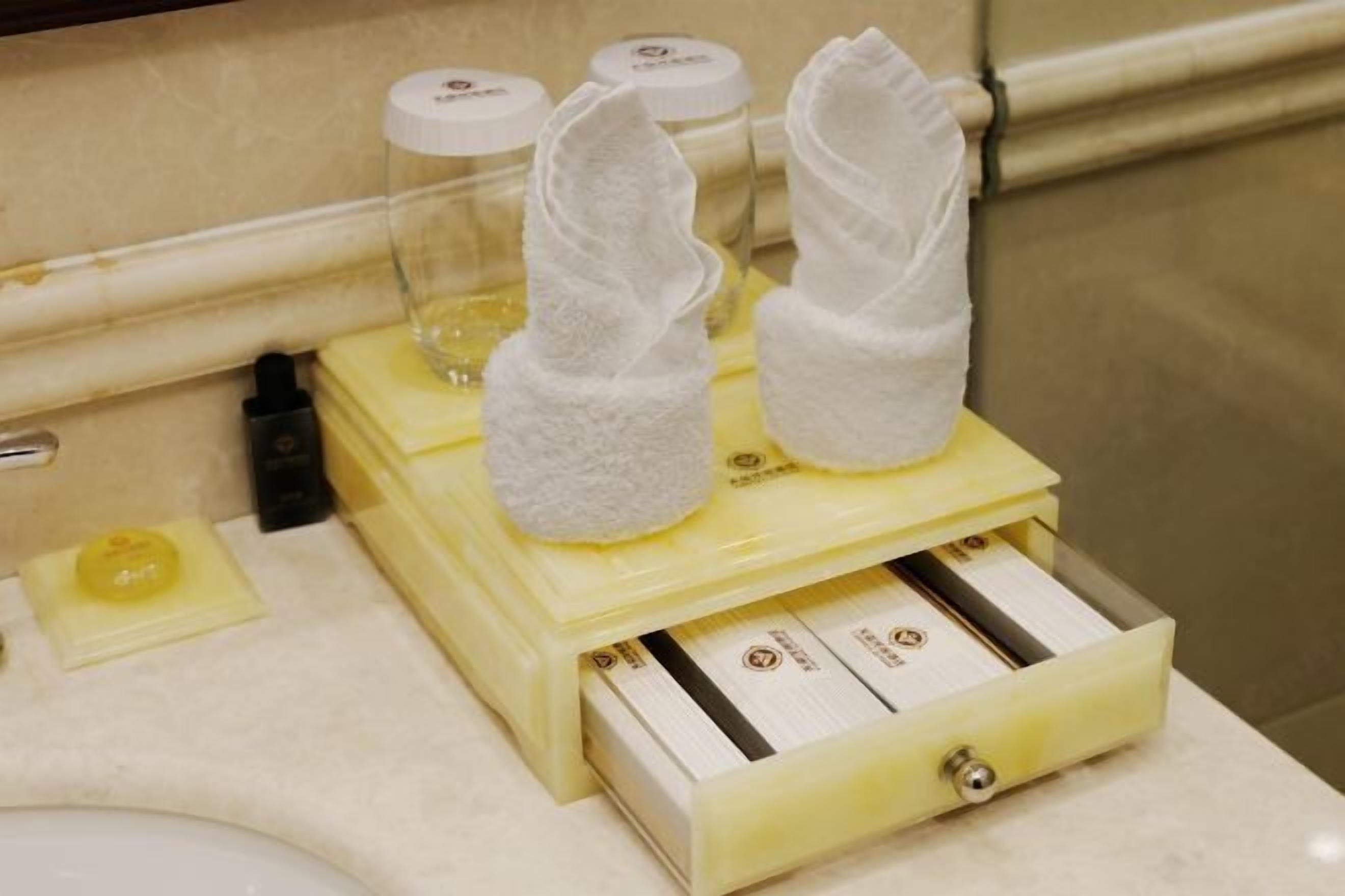 A bathroom with a towel dispenser and a soap dispenser on the counter.
