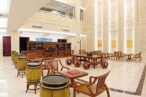 A spacious library with high ceilings, multiple tables, and wooden chairs. - Tianxi Longge Hotel (Yichang)