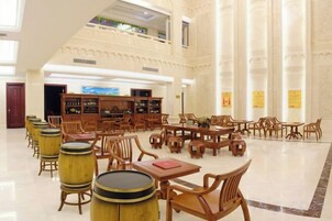 Una biblioteca espaciosa con techos altos, varias mesas y sillas de madera.