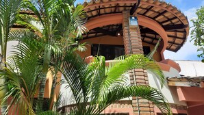 Un bâtiment doté d’un toit incurvé, de piliers en briques et d’une enseigne indiquant la présence d’un réseau Wi-Fi.