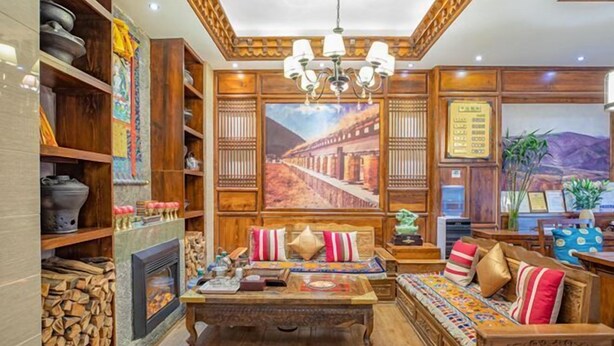 A traditional room with wooden furniture, a fireplace, and a large painting of a bridge. - Ruifeng Impressed Hotel (Shangri-La)