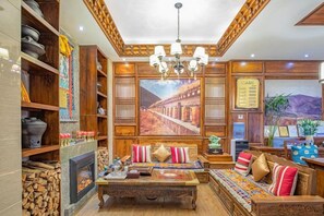 A traditional interior with a sofa set, wooden shelves, and a fireplace. - Ruifeng Impressed Hotel (Shangri-La)