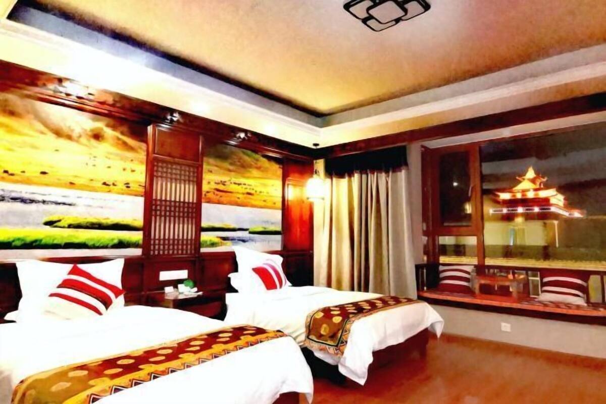 Camera d'albergo con due letti, una grande finestra vista pagoda e un affresco sulla parete.