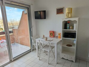 Enjoy a functional room with a balcony offering views of a brick building and trees.