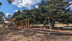 A playground with swings and a climbing structure.