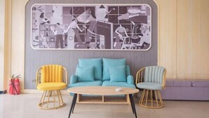 A room with a sofa, two chairs, a coffee table, and a wall art piece. - Shankee Hotel (Yangzhou Chahe University Town) (Yangzhou)