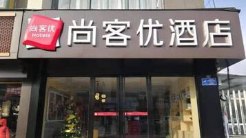 A hotel sign with the name '尚客优酒店' and a red 'Hotels' logo.